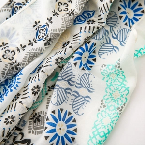 Detail of ethnic cotton linen scarf showing blue floral prints and geometric textures