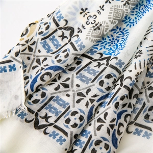 Close-up of cotton linen scarf with blue floral print and raw fringe edge details