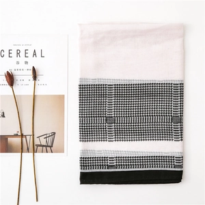 Flat lay of lightweight pink houndstooth scarf with elegant lifestyle props
