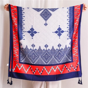 Detail view of geometric ethnic print scarf with blue tassels and vibrant patterns