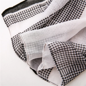 Detailed macro shot of houndstooth pattern scarf fabric with professional hemmed edges