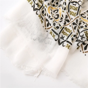 Detailed macro view of bohemian paisley gold stamp patterns on cotton linen shawl with fringe