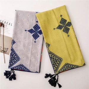Detailed view of geometric patterns and deep blue tassels on soft cotton-linen scarves