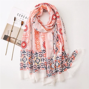 Detailed view of pink cotton linen shawl featuring golden floral prints and fringe edges