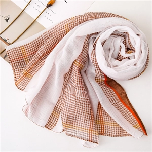 Close-up detail of lightweight houndstooth scarf with orange and brown stripes