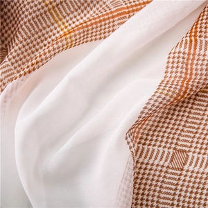 Detail of lightweight houndstooth scarf showing soft fabric texture and vintage brown pattern