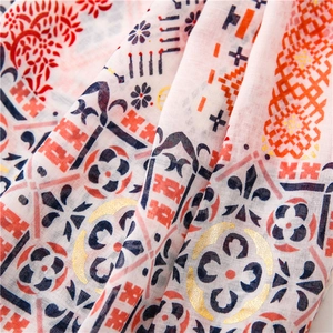 Detailed close-up of cotton linen shawl with gold foil paisley and geometric patterns