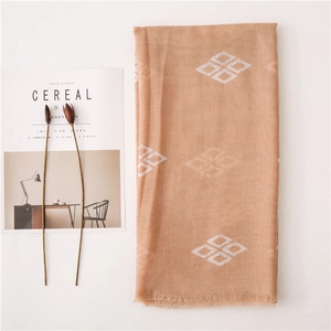 Light brown rectangle scarf with white geometric diamond patterns and fringe details