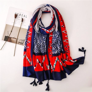 Ethnic geometric scarf with red and blue patterns and tassels on cream background