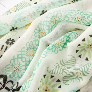 Detail of cotton linen scarf with gold foil paisley and green geometric pattern textures