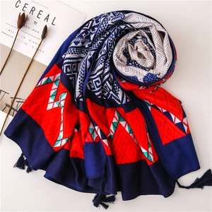 Detailed flat lay of geometric print scarf with dark blue tassels and aesthetic decor
