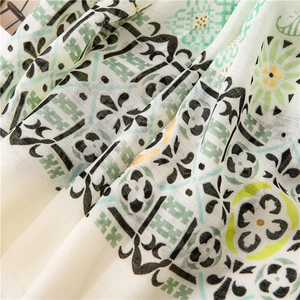 Detailed macro view of cotton linen scarf with gold foil accents and floral patterns