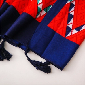 Close-up of geometric pattern on red cotton scarf with dark blue tassels and fringe