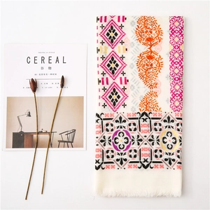 Detail of bohemian cotton linen shawl with paisley prints and tassels on a flat lay