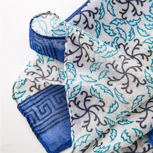 Dettaglio di sciarpa in cotone e lino con stampe floreali blu e trama del tessuto