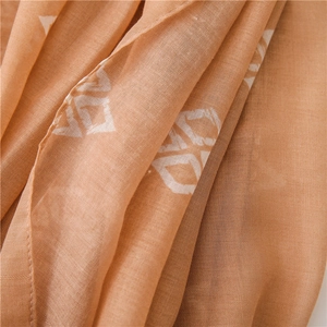 Close-up of caramel fabric shawl featuring white geometric prints and fine hemmed edges