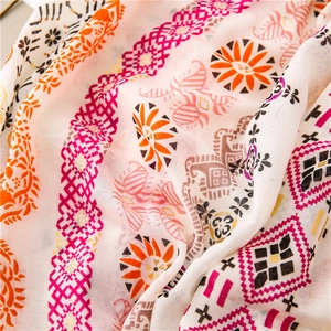 Close-up of paisley pattern on white cotton linen shawl with golden foil accents