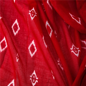 Detailed macro view of red ikat geometric print fabric with soft drape and texture