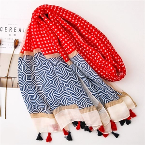 Detail of multi-color plaid scarf with blue geometric patterns and fringe edges