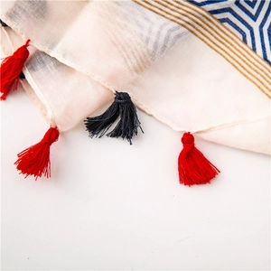 Close-up of geometric star pattern scarf with handmade red and navy blue tassels