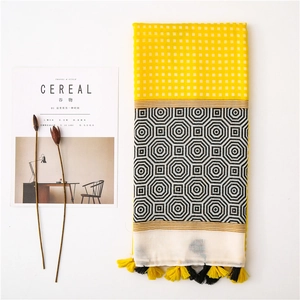 Detailed flat lay of a patchwork tassel scarf with geometric patterns and fringe detail