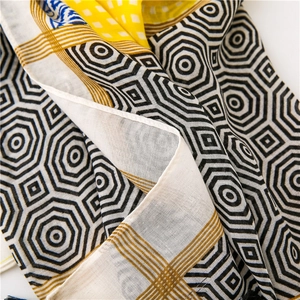 Macro shot of geometric print scarf showing soft cotton-linen fabric and textured patterns