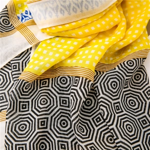 Close-up of geometric pattern fashion scarf with vibrant yellow and blue woven textures