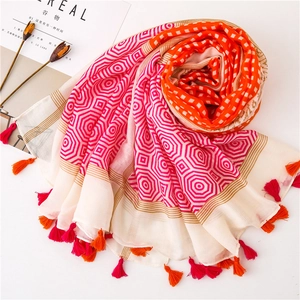 Detail of colorful shawl with orange checkerboard pattern, pink geometry, and fringe