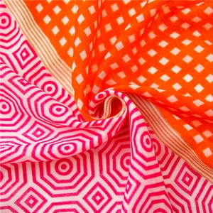 Detail of checkered orange and fuchsia geometric pattern fabric with textured weave