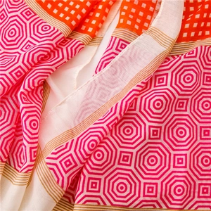 Detail showing colorful geometric print on lightweight fabric with vibrant pink and orange hues