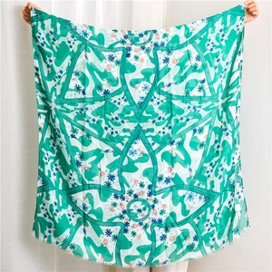 Floral print square shawl scarf with green geometric pattern and delicate fringed edges