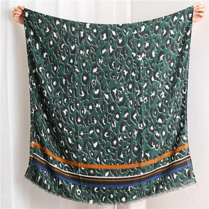 Detail of leopard print scarf with colorful striped borders and fringe edges