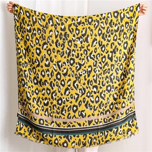 Detail of vibrant yellow leopard print scarf with horizontal stripes and fringed edges