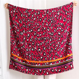 Close-up of red leopard print scarf with colorful striped edges and frayed hem details