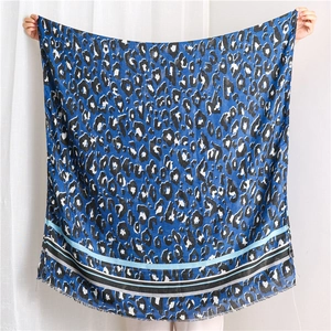 Detail of royal blue leopard print scarf showing fine frayed edges and semi-sheer texture