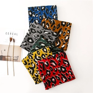 Detail view of multi-colored leopard print scarves with subtle fringed edges and soft texture