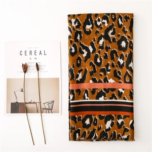 Detail of leopard print scarf with colorful stripes on a minimalist magazine layout