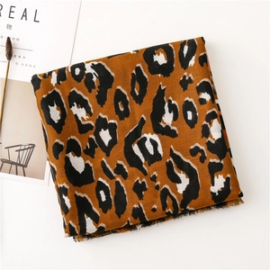 Detailed close-up of leopard print scarf with soft fringe edges on a white background