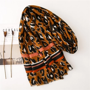 Close-up of leopard print scarf with striped trim and delicate tassel edges detail