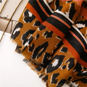 Close-up of leopard print cotton-linen scarf with diagonal weave and tassel fringe