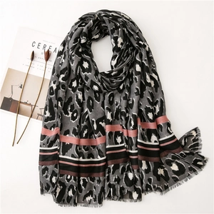 Close-up of leopard print scarf with striped edge details and natural fringe texture