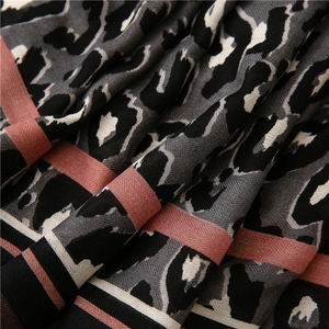 Detail shot of leopard print scarf fabric showing twill weave and pink stripe accents