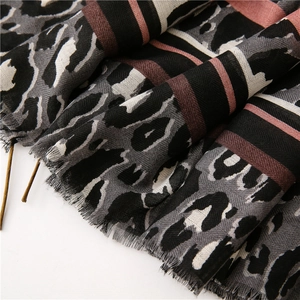 Close-up of leopard print and color block striped scarf showing soft fringe details
