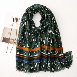 Detail of leopard print scarf with colorful stripes and frayed fringe edges on white background