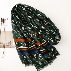 Detail of green leopard print scarf with colorful stripes and soft frayed edges