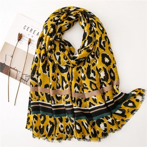 Colorful leopard print scarf with striped edges and fringe tassels on white background