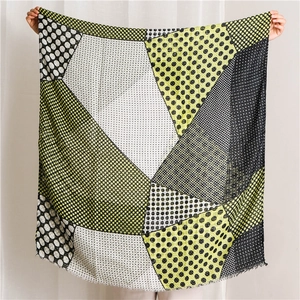 Macro detail of breathable black and yellow plaid scarf with fringe and dot pattern