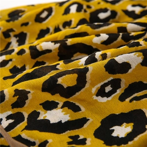 Close-up of yellow leopard print scarf fabric showing detailed diagonal twill texture
