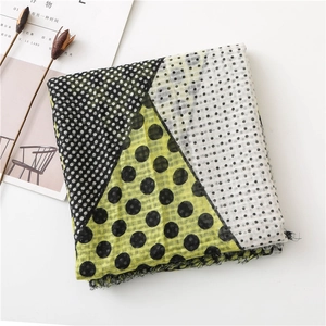 Detail of plaid scarf with black polka dots and mustard yellow geometric color blocks