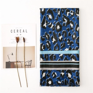 Detailed close-up of blue leopard print scarf with striped patterns and frayed edges